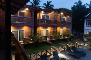a building with tables and chairs in front of it at Tranquillo By The Beach in Candolim