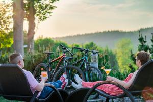 um grupo de pessoas sentadas em cadeiras com bebidas em Malinowy Dwór Hotel Medical SPA em Świeradów-Zdrój