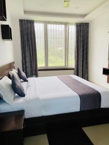 a bedroom with a large bed with pillows at Cool breeze view Homestay in Madikeri