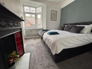 a bedroom with a large bed and a fireplace at Church Stretton Shropshire Hills in Church Stretton