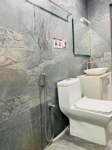 a bathroom with a white toilet and a shower at Cool breeze view Homestay in Madikeri +17 photos