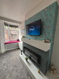 a living room with a fireplace with a tv above it at Church Stretton Shropshire Hills in Church Stretton
