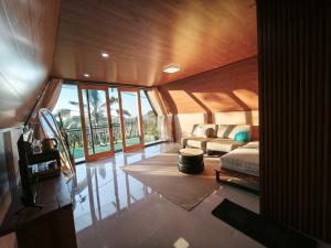 ein Wohnzimmer mit einem Bett und einer Couch in der Unterkunft Casa Vella Cottage in Patjung