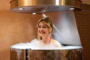 una mujer tomando un baño en una ducha en Malinowy Dwór Hotel Medical SPA, en Świeradów-Zdrój