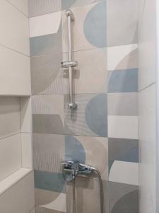 a bathroom with a shower with a tile wall at Rias Efthimiou House in Kanallaki