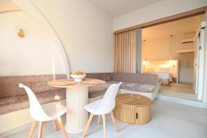 a living room with a table and chairs and a bed at Skalia Mountain & Sea Suites in Skaliá +13 photos