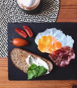 a plate of breakfast food with eggs bacon and tomatoes at ő s z a p ó in Vöröstó +5 photos
