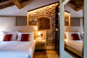 a hotel room with two beds and a mirror at Corte Regia Relais & Spa in Valeggio sul Mincio +211 photos