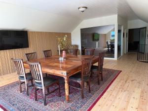 Dorisberg B&B - The Stables في Löberöd: طاولة طعام خشبية وكراسي موضوعة على سجادة