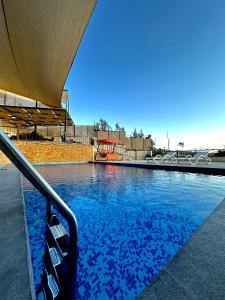 a swimming pool with blue water and a playground at sama vailla in Amman