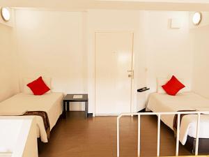 a room with two beds with red pillows at Siam Villa Suvarnabhumi in Ban Khlong Si