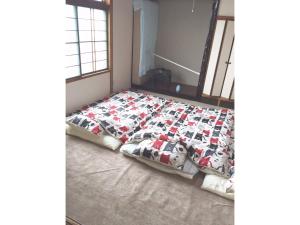 a bed with a quilt on it in a room at Guest House Hagoromo 39 - Vacation STAY 12003v in Kiyosato