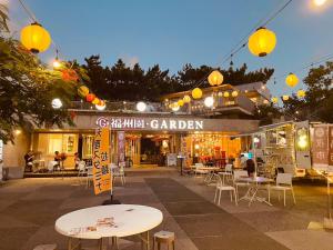 a patio with tables and chairs in front of a market at 希少新築 家族 グループ歓迎 国際通り近く 4泊以上10offキャンペーン中 in Naha