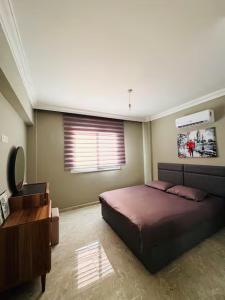 a bedroom with a large bed and a window at Royal Sun Elite Daire in Aglantzia