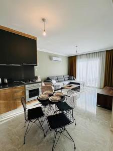 a living room with a table and some chairs at Royal Sun Elite Daire in Aglantzia