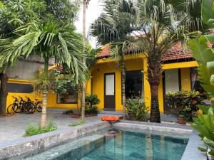 een geel huis met een zwembad voor een huis bij Tam Coc Mango Homestay - Free Swimming Pool in Ninh Binh