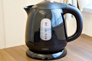a black coffee pot sitting on top of a table at Daruma Mansion - Vacation STAY 16088v in Naha