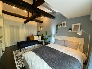 a bedroom with a large bed and a couch at Nagasaki Sakayado Hitoma - Vacation STAY 16332v in Nagasaki