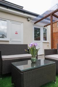 a table with a vase of flowers on a patio at 45GR Dreams Unlimited Contractor Home in Harrow in Harrow