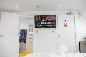 a room with a tv on a wall with a bed at 45GR Dreams Unlimited Contractor Home in Harrow in Harrow