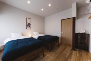 a bedroom with two beds and a cabinet at Large family accommodation Tsuji family - Vacation STAY 11297v in Mitoyo