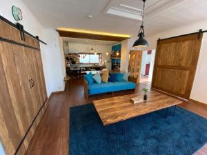 a living room with a blue couch and a table at Poroto Base - Vacation STAY 18129v in Shiraoi