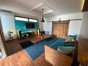 a living room with a blue couch and a tv at Poroto Base - Vacation STAY 18129v in Shiraoi