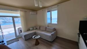 a living room with a couch and a large window at TopView Apartment In front of Saranda Port in Sarandë