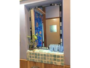 a mirror with blue cups on a brick ledge at Woman Only Ohenro House33 - Vacation STAY 27239v in Kochi