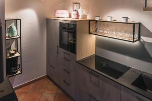 a kitchen with a counter with wine glasses in it at Dorfchalets - Chalet Alma inkl Tauern Spa Therme Eintritt & Sommerkarte in Kaprun