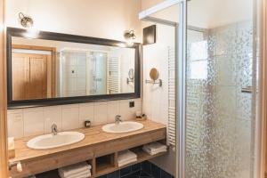 a bathroom with two sinks and a shower at Dorfchalets - Chalet Alma inkl Tauern Spa Therme Eintritt & Sommerkarte in Kaprun