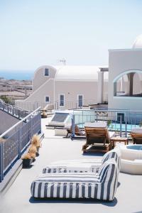 a rooftop deck with lounge chairs and a pool at Akron Ariston Suites in Akrotiri