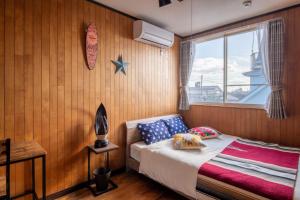 a bedroom with a bed and a window with a surfboard on the wall at VILLENT KUJUKURI ARROW - Vacation STAY 32961v in Kujukuri