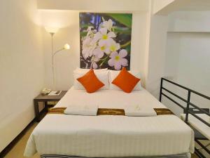 a bedroom with a bed with a painting on the wall at Siam Villa Suvarnabhumi in Ban Khlong Si