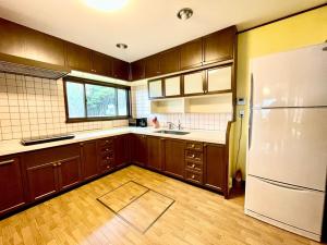 a kitchen with wooden cabinets and a white refrigerator at BLUE AMALFI - Vacation STAY 28035v in Ōbe