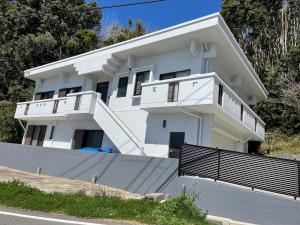 a white house with two balconies on it at Coast house Nabura - Vacation STAY 29534v in Nagasaki