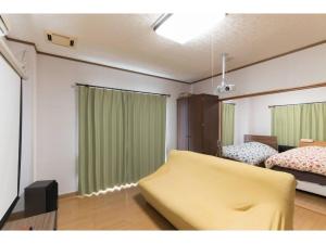 a living room with a yellow couch and a bed at Yado wa Good Rich - Vacation STAY 30399v in Tokushima