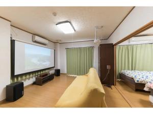 a room with a large screen with a bed and a tv at Yado wa Good Rich - Vacation STAY 30399v in Tokushima