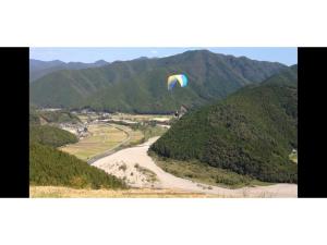 a person is flying a kite over a mountain at Yado wa Good Rich - Vacation STAY 30399v in Tokushima