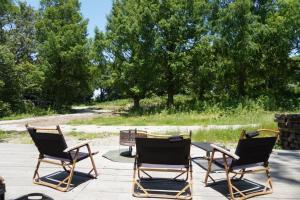 three chairs and a table on a patio at Jyuuraku no mori - Vacation STAY 50432v in Awara