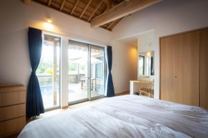a bedroom with a large bed and a large window at Villa Muse Okinawa- Vacation STAY 43827v in Nago +20 photos