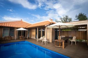 a house with a swimming pool and a patio with a table and umbrella at Villa Muse Okinawa- Vacation STAY 43827v in Nago