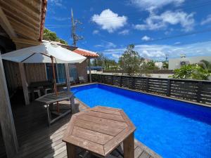 a pool with an umbrella and a table next to a house at The Villa with a YAMAHA C6X - Villa Muse Okinawa- Vacation STAY 43827v in Nago