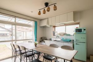 a kitchen with a table and chairs and a refrigerator at VIILENT KUJUKURI Ocean1 - Vacation STAY 33286v in Kujukuri