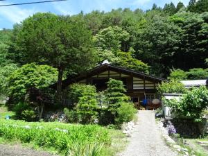 a house in the woods with a path leading to it at Minshuku Otaki fireplace - Vacation STAY 46344v in Miyaki