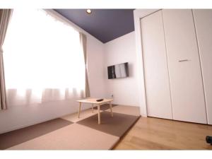 una stanza con un tavolo e una grande finestra di HOTEL APT SESELA - Vacation STAY 12882 a Kanazawa Altre 7 foto