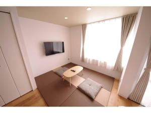 a small living room with a table and a tv at HOTEL APT SESELA - Vacation STAY 12881 in Kanazawa