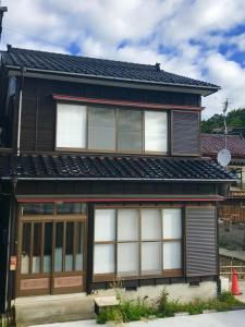 a house with white windows and a black roof at Lu Blue Sado SAWANE - Vacation STAY 12885 in Sado +9 photos