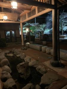 a pond with rocks in a building at night at Private guest house with veranda without bath and shower - Vacation STAY 47236v in Toyooka