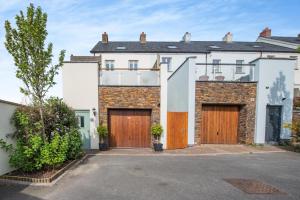an exterior view of a house with wooden doors at Cartref - Saundersfoot in Saundersfoot